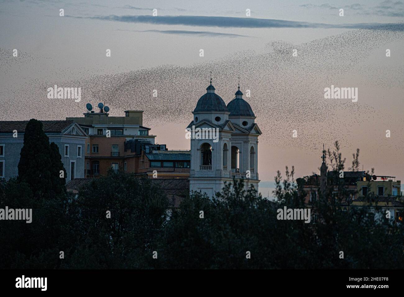 ROM, ITALIEN. 7. Januar 2022. Bei einem farbenfrohen Sonnenuntergang über Rom schwungvolle Murmeln über der Kirche der Santissima in Trinità dei Monti. Kredit: amer ghazzal/Alamy Live Nachrichten Stockfoto