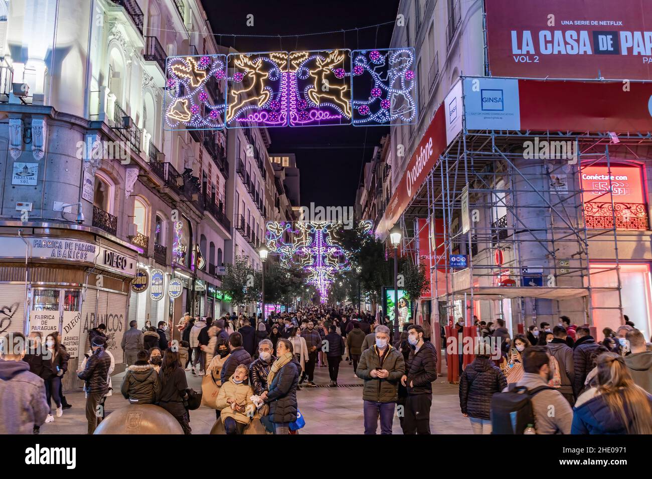 Madrid, Spanien - 11. Dezember 2021: Menschenmenge von nicht identifizierten Menschen, die Madrid zur Christmast-Zeit umherwandern. Sie tragen eine schützende Gesichtsmaske Stockfoto