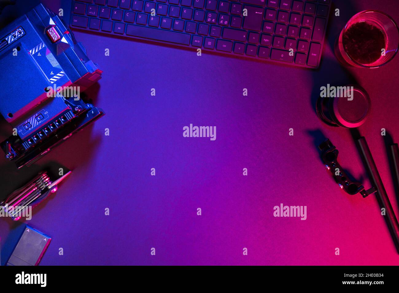 Direkt über Aufnahme der Tastatur mit Videokamera und Kaffee auf beleuchtetem Tisch Stockfoto