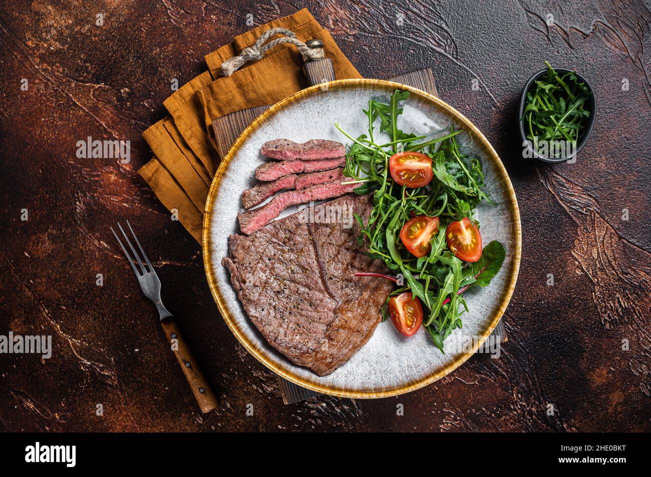 Diner mit gegrilltem Rinderfleisch-Steaks und Gemüsesalat. Dunkler Hintergrund. Draufsicht Stockfoto