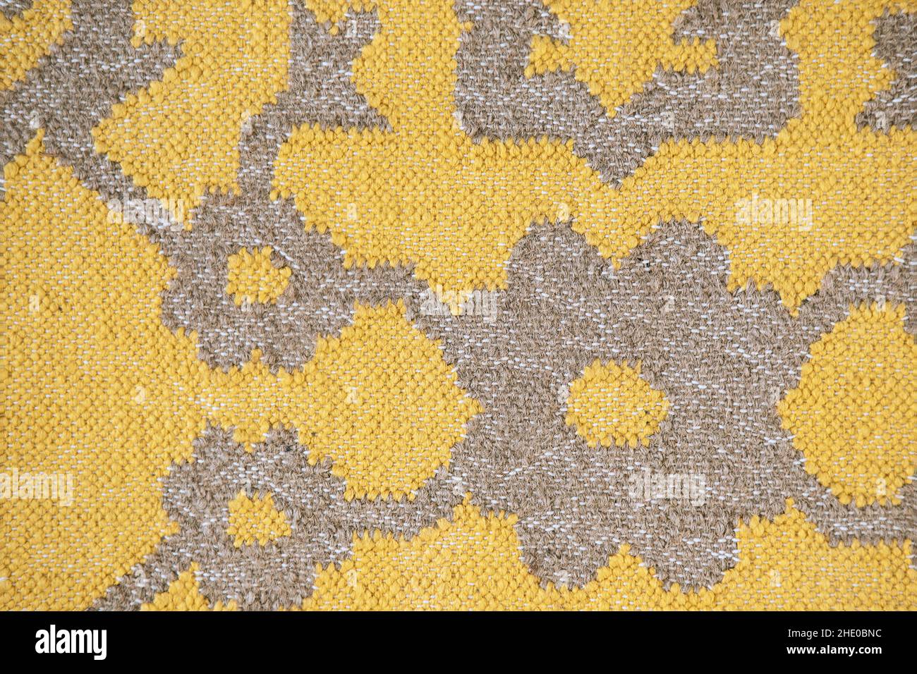 Gelbes Textil mit abstraktem Ethno-Muster in Nahaufnahme und sichtbarer Textur. Qualität im Folk-Stil. Stockfoto