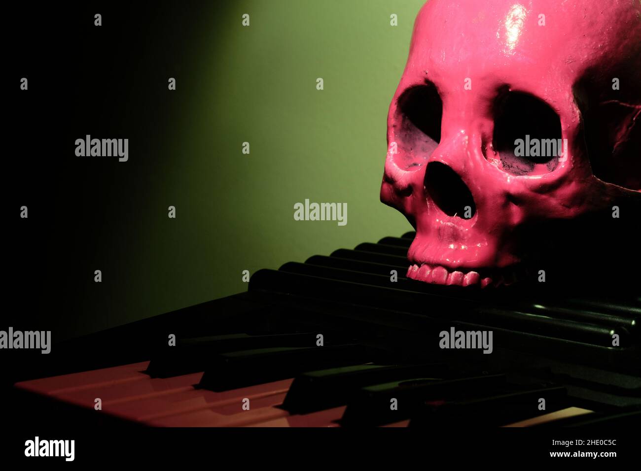 Pink Human Skull auf E-Piano Keyboard für beängstigende musikalische Darbietung Stockfoto