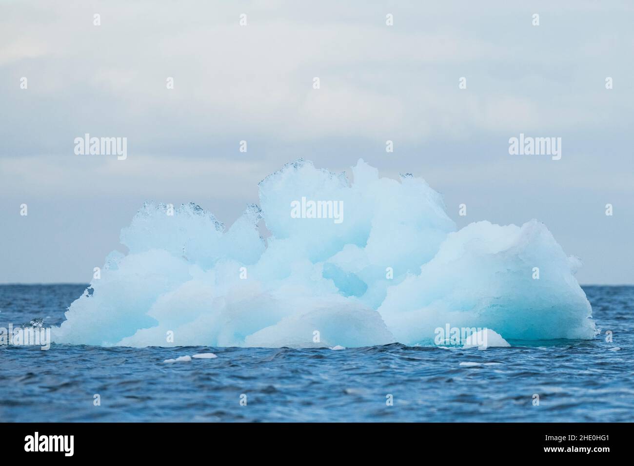 Ein blauer Eisberg schwimmt im südlichen Ozean, vor der Küste der Antarktis. Stockfoto