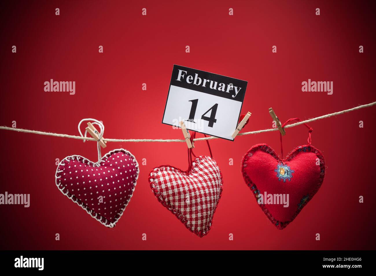 14. Februar, im Kalender, Valentinstag, rotes Herz, roter Hintergrund Stockfoto