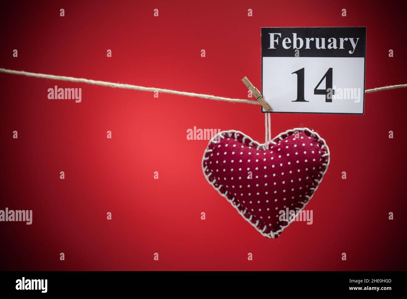 14. Februar, im Kalender, Valentinstag, rotes Herz, roter Hintergrund Stockfoto