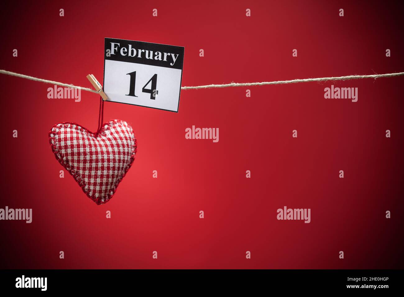 14. Februar, im Kalender, Valentinstag, rotes Herz, roter Hintergrund Stockfoto