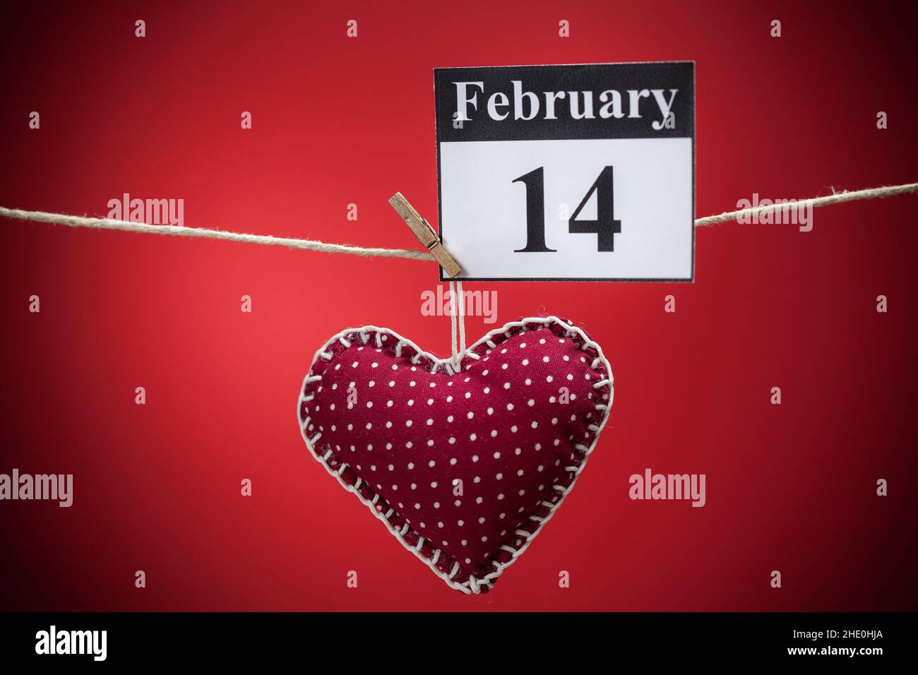 14. Februar, im Kalender, Valentinstag, rotes Herz, roter Hintergrund Stockfoto