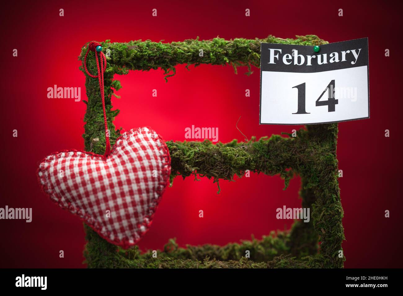 14. Februar, im Kalender, Valentinstag, rotes Herz, roter Hintergrund Stockfoto