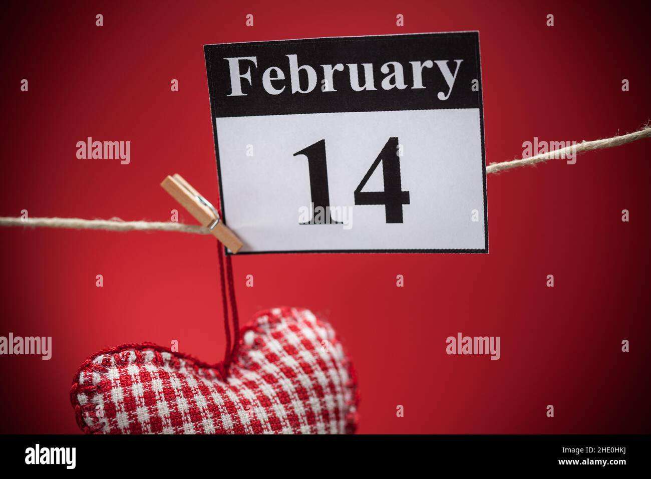 14. Februar, im Kalender, Valentinstag, rotes Herz, roter Hintergrund Stockfoto