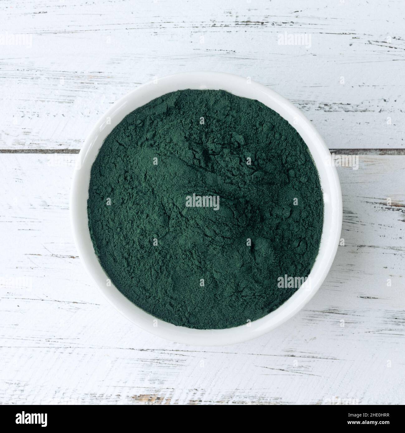 Spirulina Algenpulver in einer Schüssel über einem Holztisch. Stockfoto