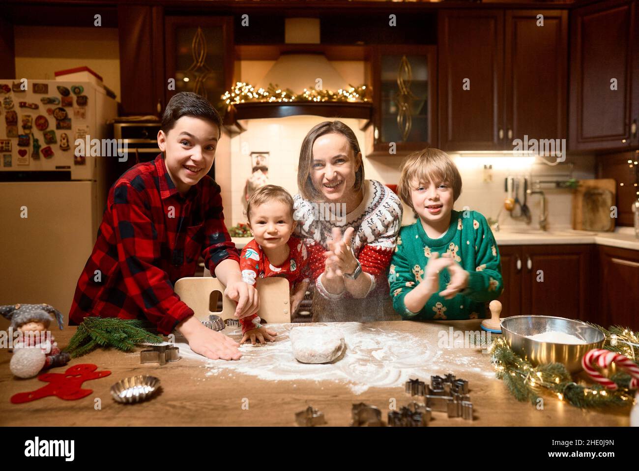 Familie mit drei Kindern kocht Ingwerkekse. Frohe Weihnachten, Frohes neues Jahr. Familienzeit, Vorbereitung auf den Urlaub. Stockfoto