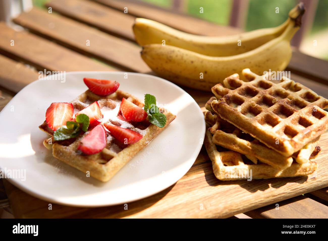 Waffeln mit Erdbeeren, Bananen und Honig. Stockfoto
