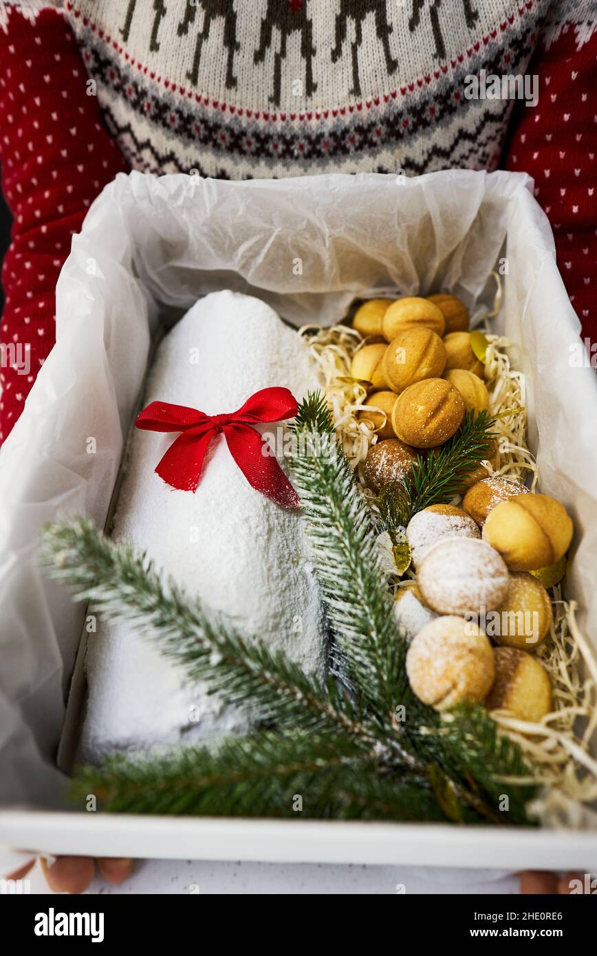 Traditioneller Weihnachtsstollen aus getrockneten Früchten und Nüssen, bestreut mit Puderzucker auf dem Hintergrund eines Weihnachtsdekor mit Kerzen Stockfoto