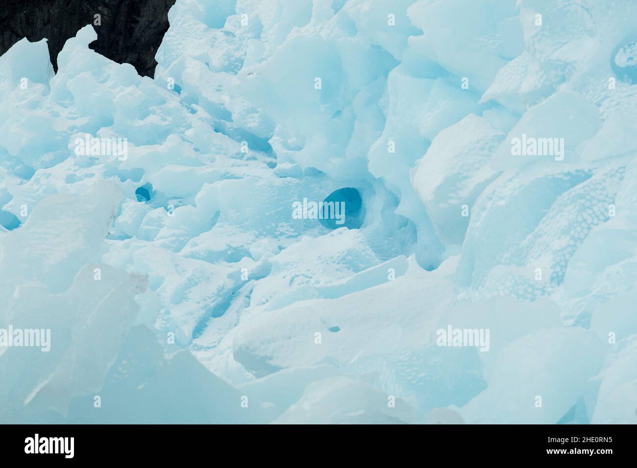 Frischer Schnee auf einem blauen Eisberg. Stockfoto