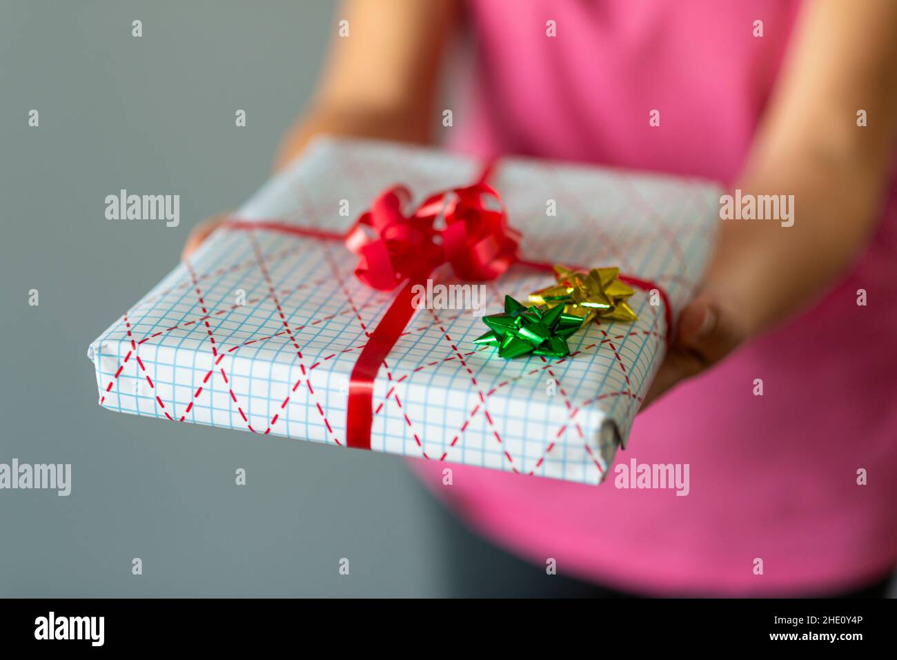 Frau reicht ein eingewickeltes Geschenk-selektiver Fokus Stockfoto