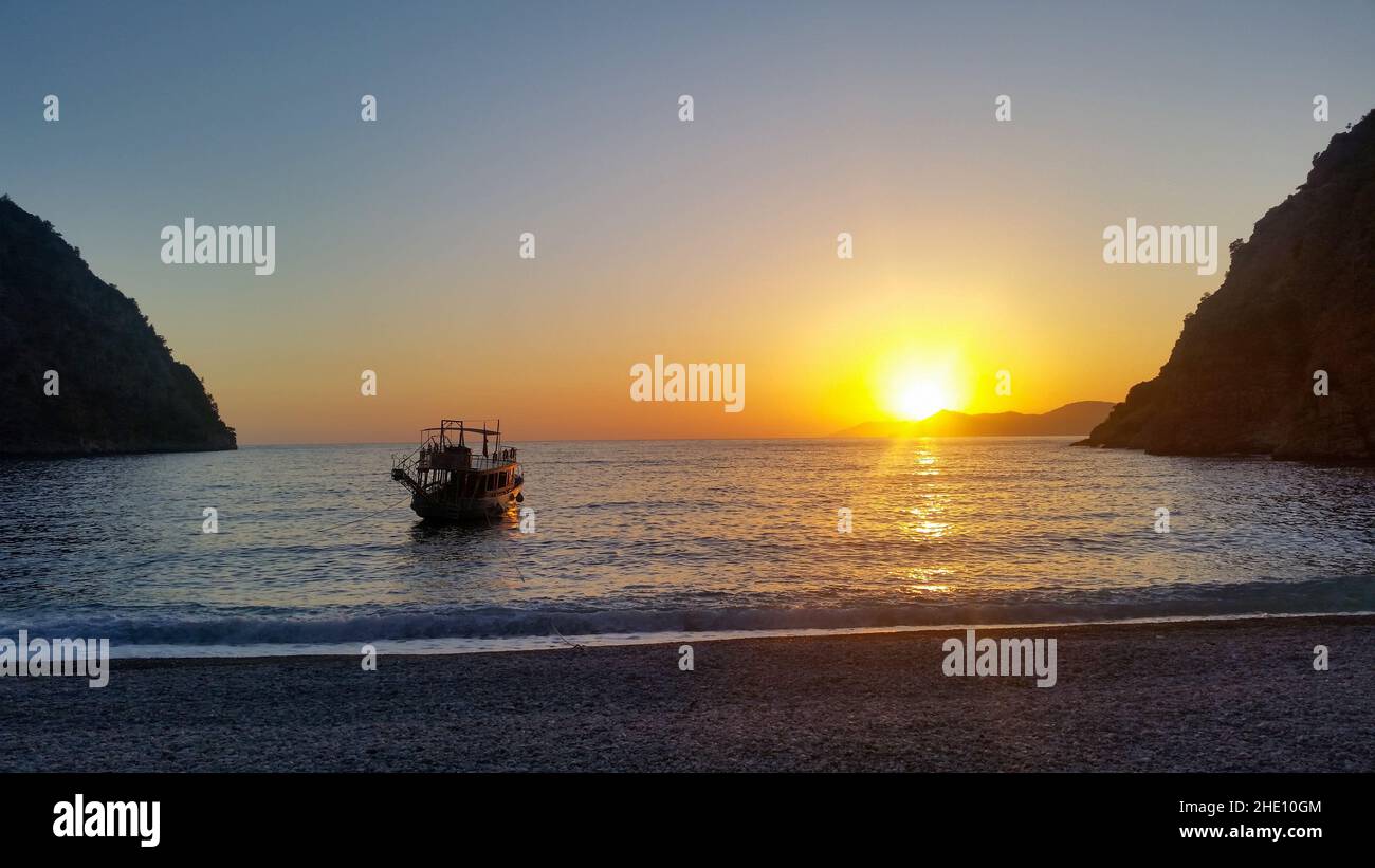 Sonnenuntergang und ein kleines Boot im Butterfly Valley, goldene Stunden. Stockfoto