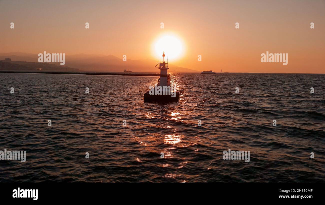 Das Lichthaus und der Sonnenuntergang auf dem Hintergrund während der goldenen Stunden. Stockfoto
