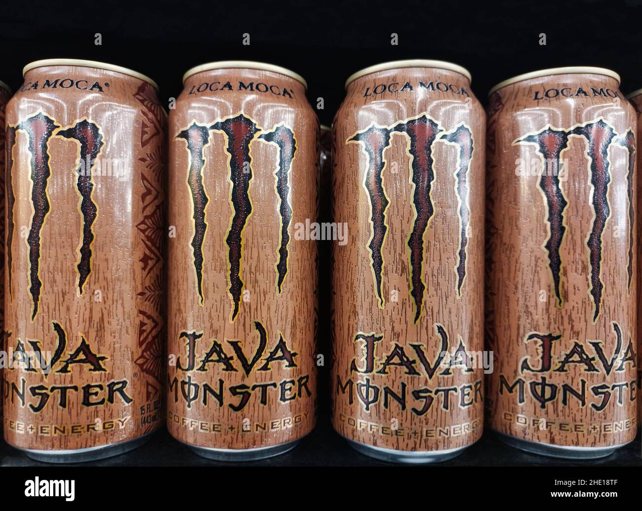 Houston, Texas USA 01-06-2022: Java Monster Energy Drink Dosen aufgereiht auf einem Supermarktregal mit schwarzem Hintergrund. Stockfoto