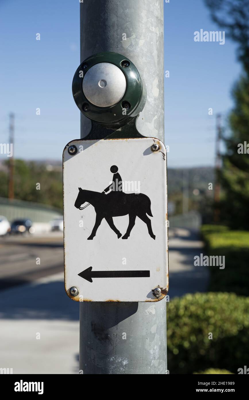 Pferd überqueren Taste und Zeichen auf einer Stange, um eine belebte Straße zu überqueren Stockfoto