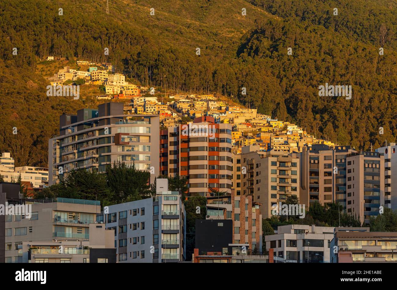 Moderne Apartmentgebäude und ein traditionelles Viertel am Pichincha Vulkan bei Sonnenaufgang, Quito, Ecuador. Stockfoto