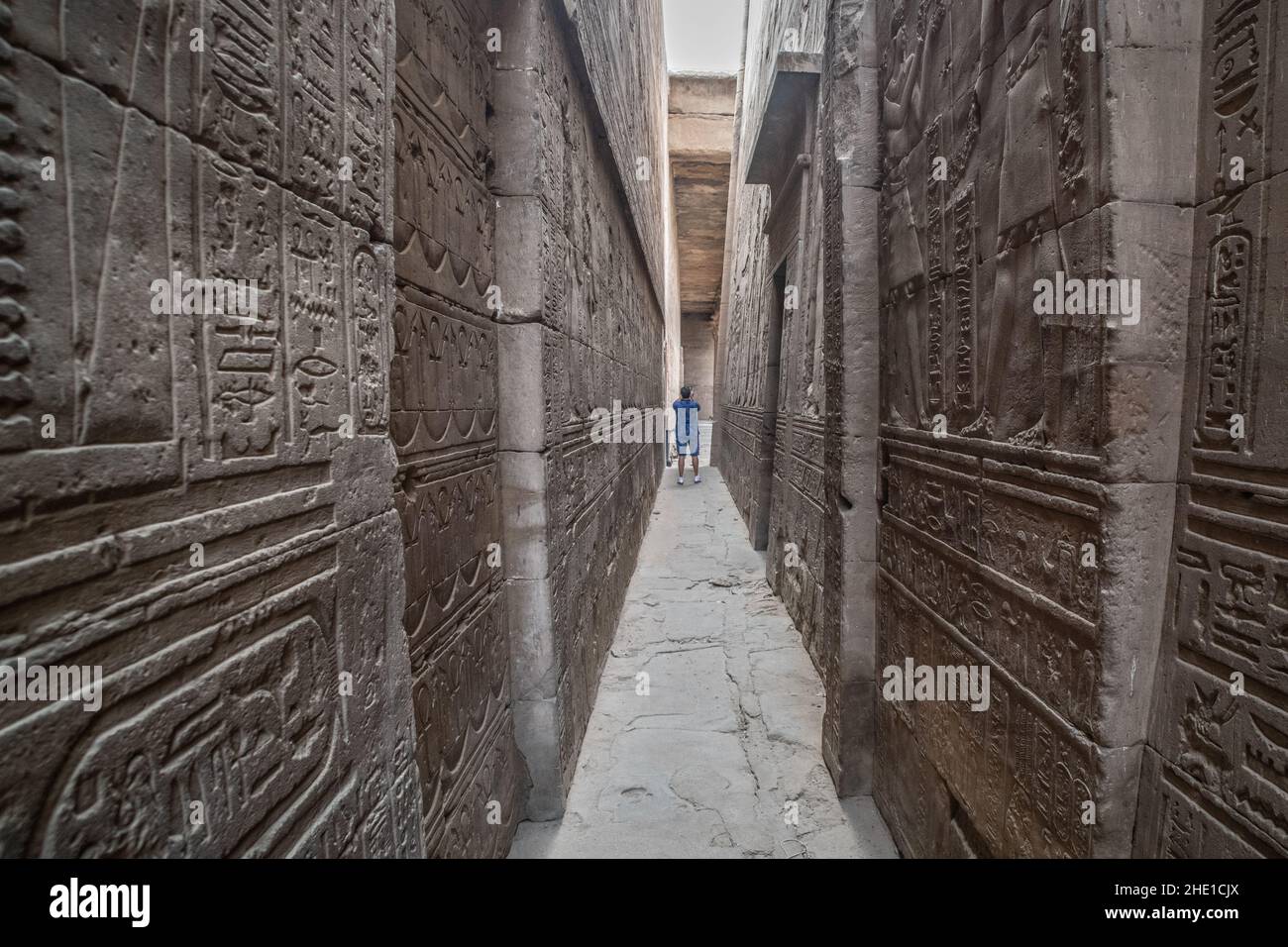 Ein reich geschnitzter und reich verzierter Steinkorridor, der mit Reliefskulpturen und Hieroglyphen im Edfu-Tempel, einer archäologischen Stätte in Ägypten, bedeckt ist Stockfoto