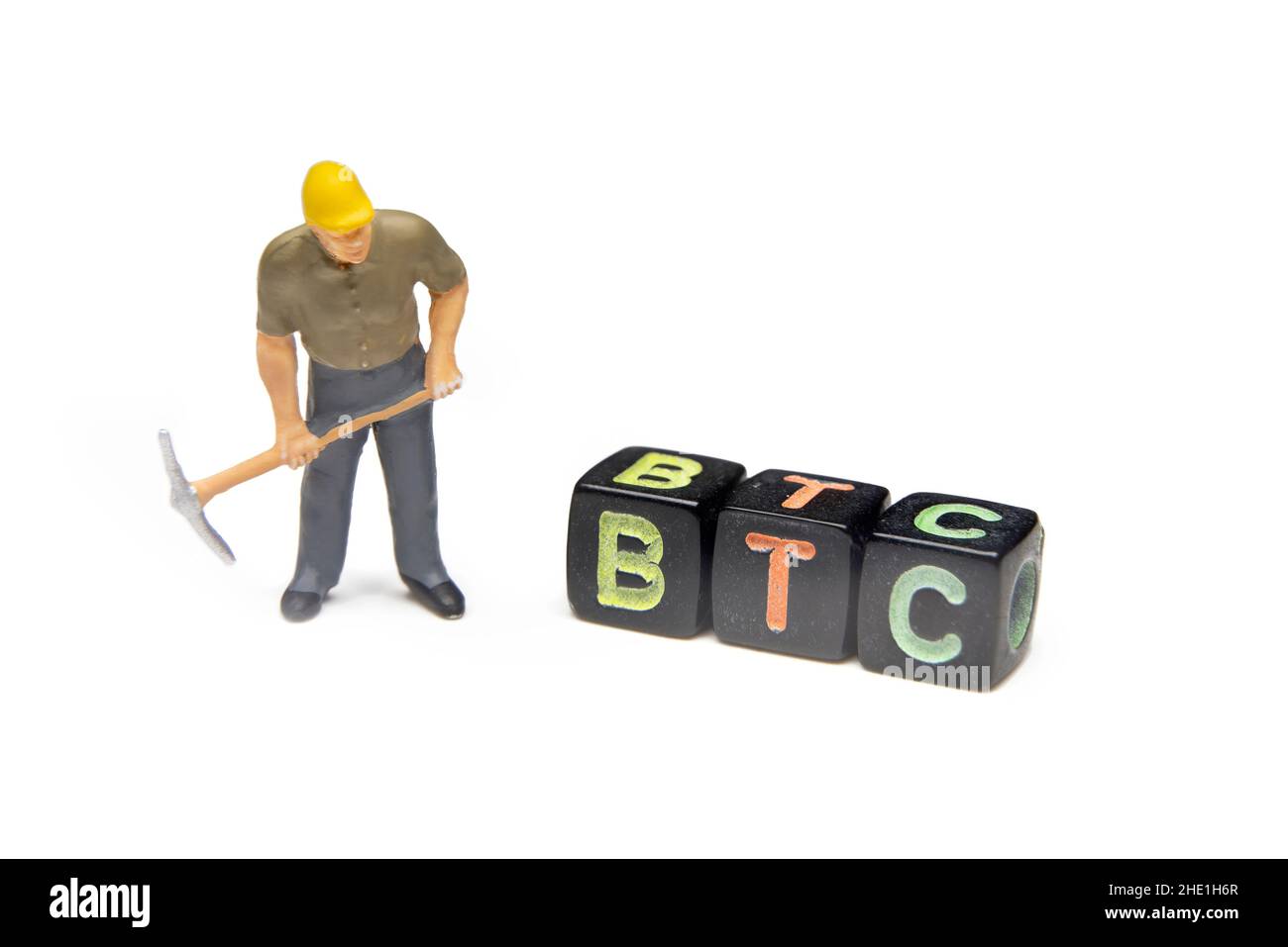 Miniaturarbeiter Aus Kunststoff Mit Pickaxe, Der Bitcoin-Würfel Betrachtet, Isoliert Auf Weißem Hintergrund Stockfoto