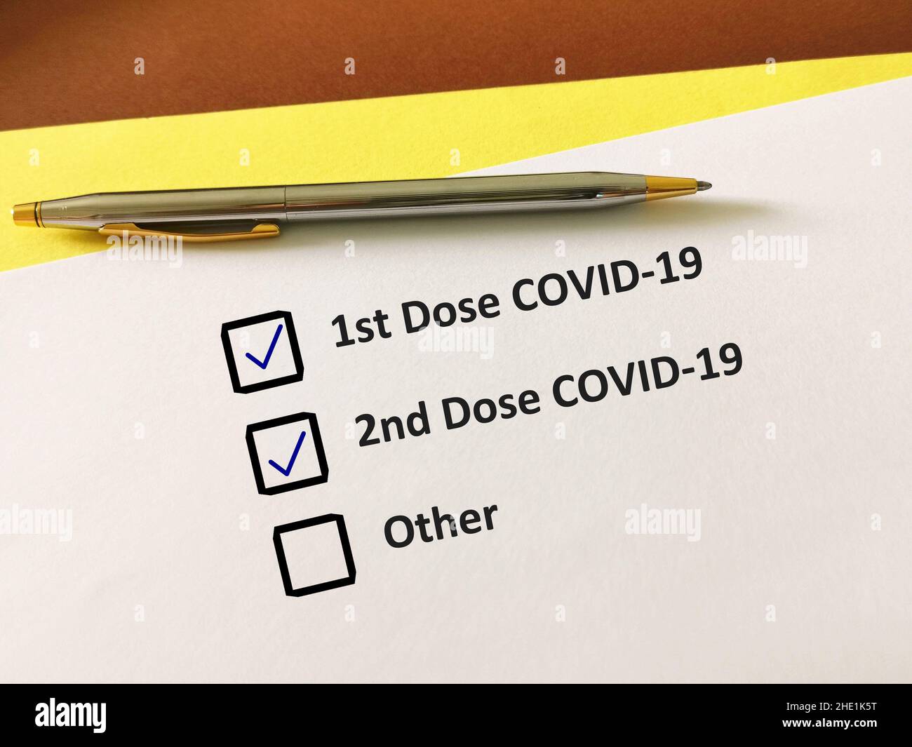 Eine Person beantwortet Fragen zu Impfstoffen. Die Person füllt die COVID-19-Karte auf. Stockfoto