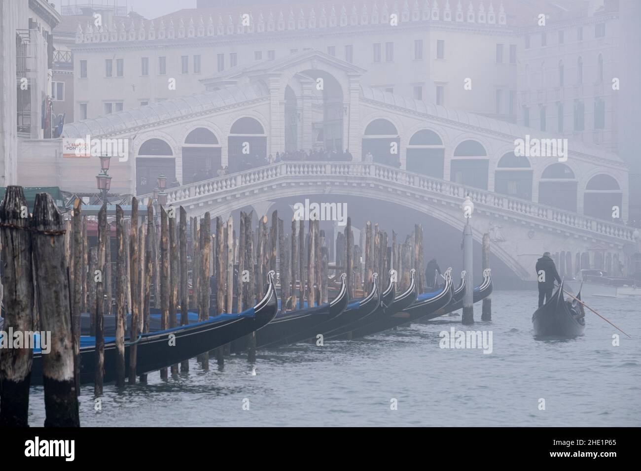 Ein Gondoliere rudern seine Gondel während einer Zeit des Nebels über den Canal Grande. Venedig, Italien, Dezember 30 2021. Stockfoto