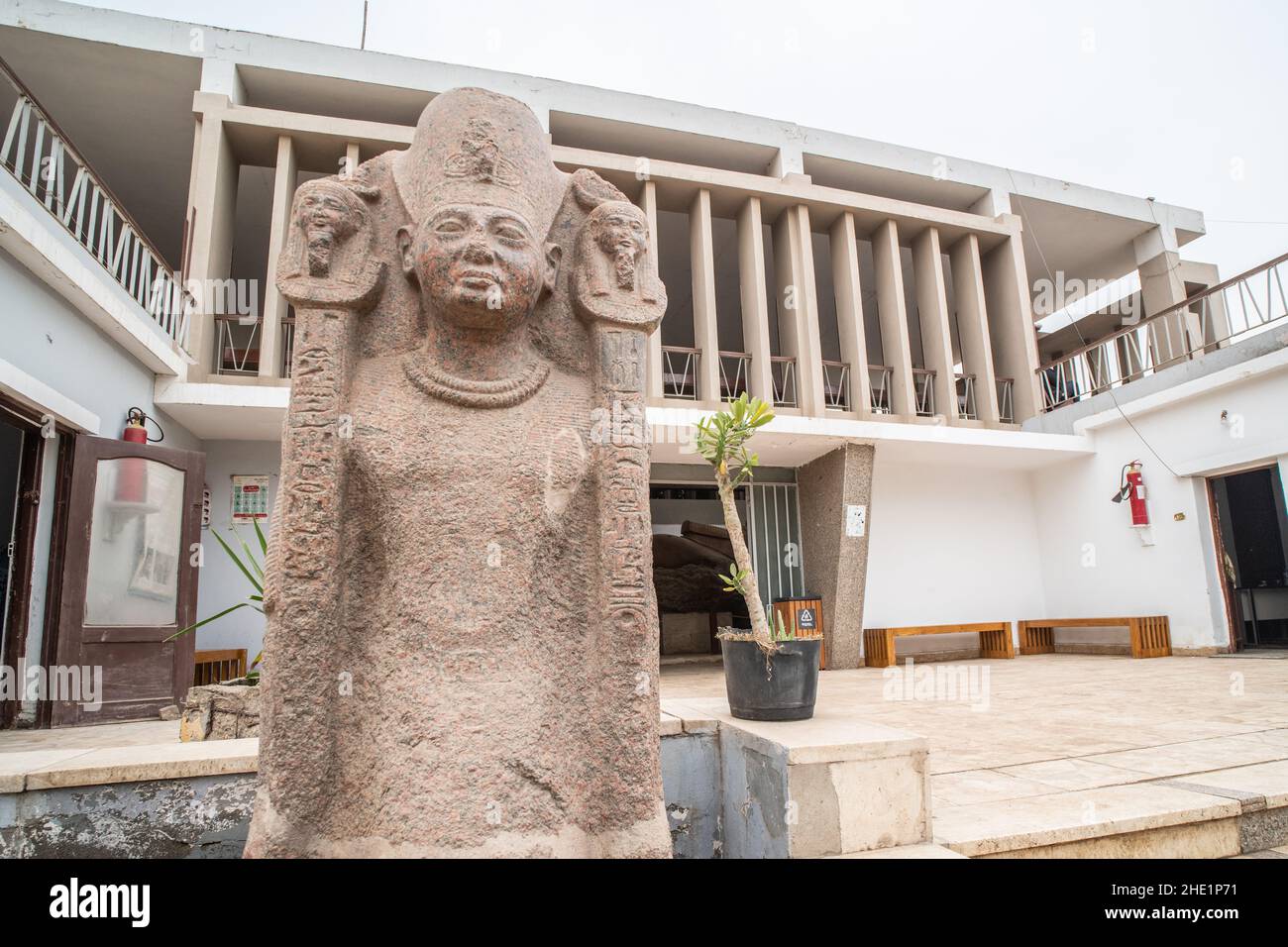 Eine Statue im Freilichtmuseum in Memphis, Ägypten, das Gebäude hinter beherbergt die riesige zerbrochene Statue von Ramses II. Stockfoto