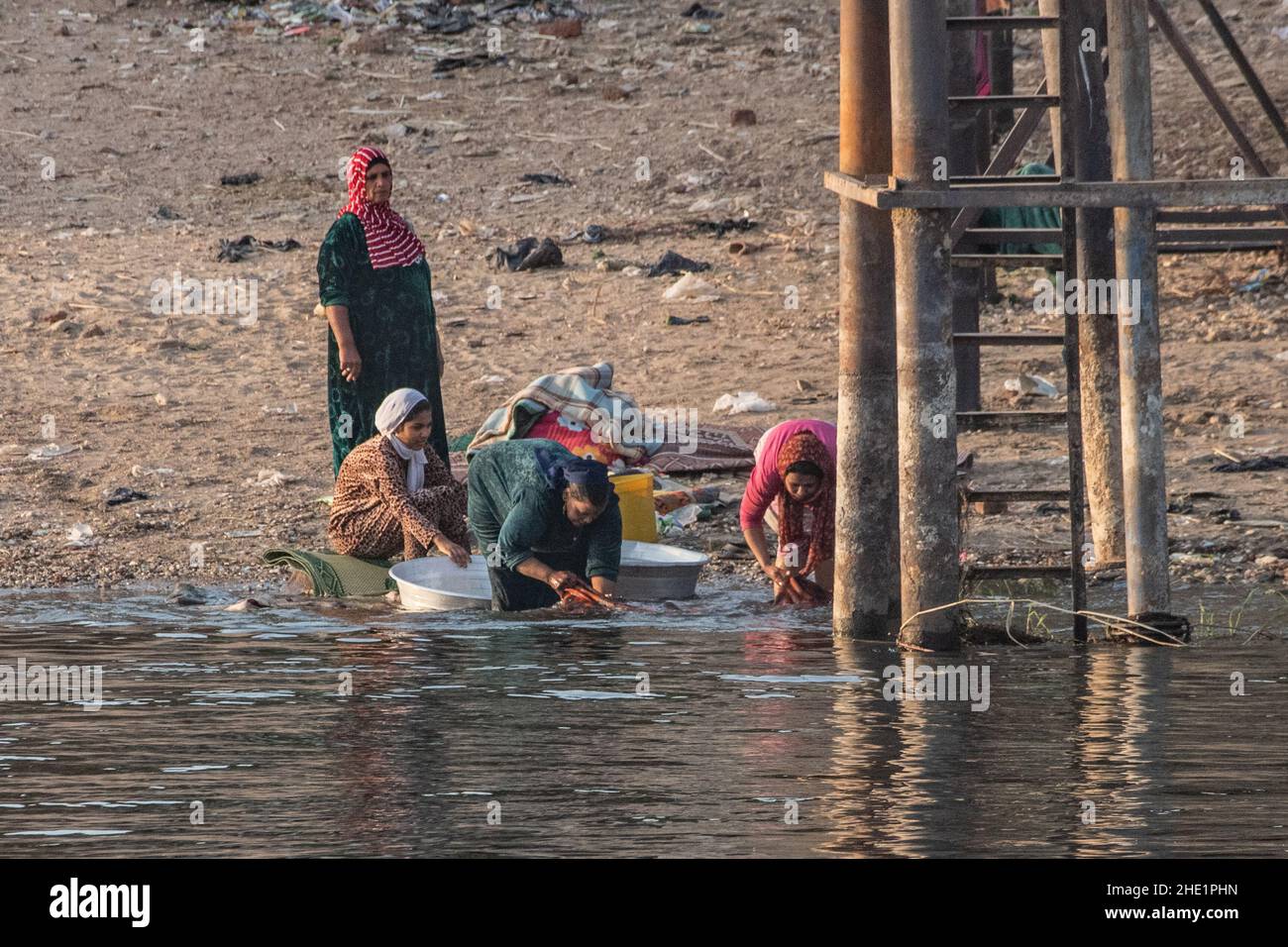 Ägyptische Frauen waschen ihre Kleidung und waschen ihre Wäsche im Nil. Stockfoto