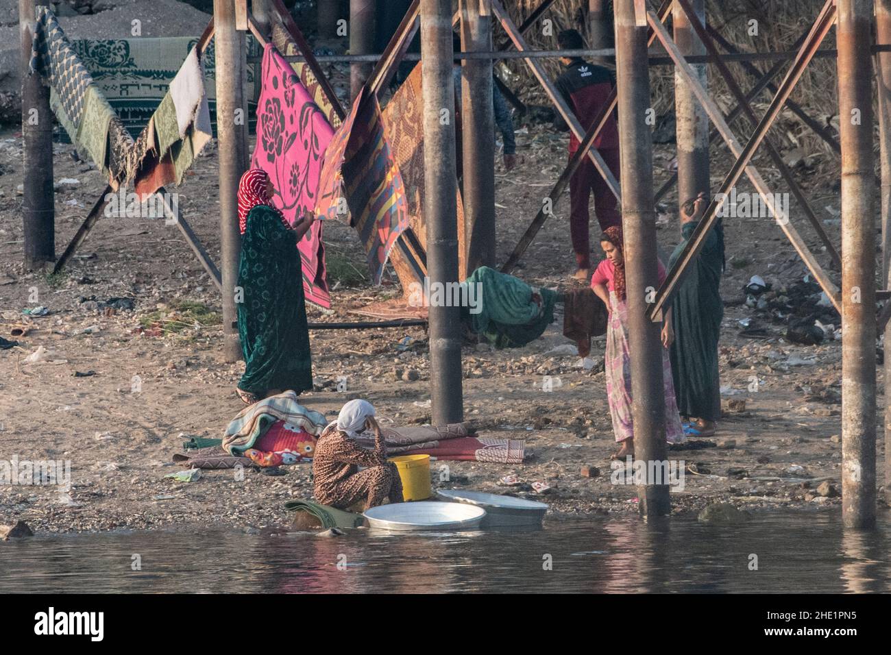 Ägyptische Frauen waschen ihre Kleidung und waschen ihre Wäsche im Nil. Stockfoto