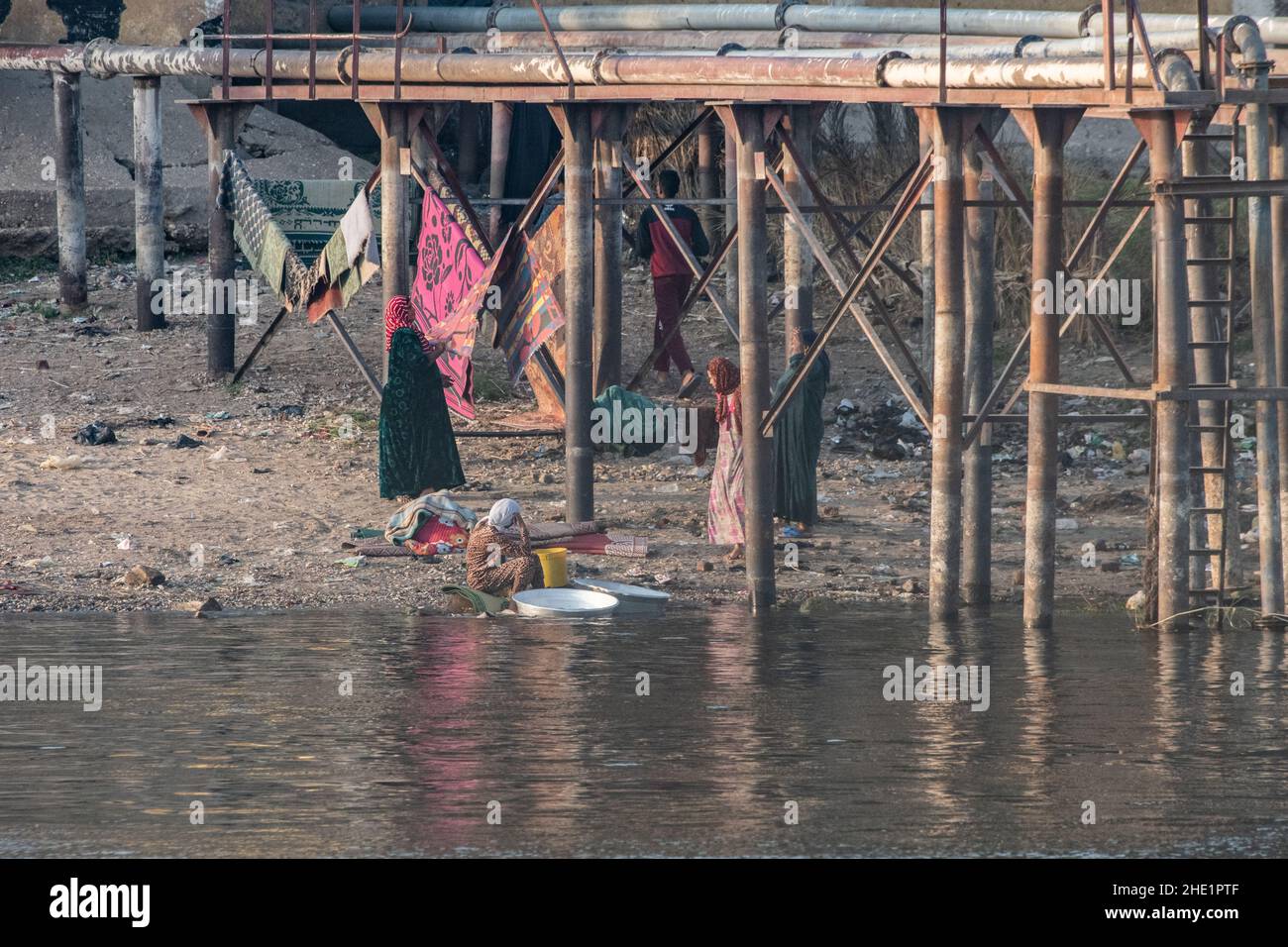 Ägyptische Frauen waschen ihre Kleidung und waschen ihre Wäsche im Nil. Stockfoto