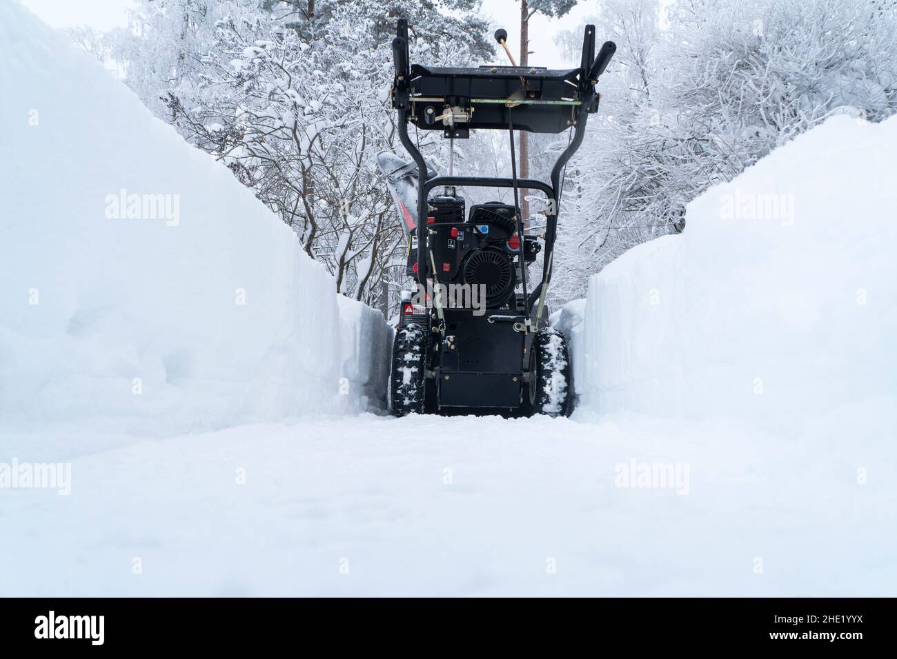 Schneegebläse bei der Arbeit an einem Wintertag. Entfernen von Schnee nach Blizzard Schneefall. Löschen des Eis. Eine Schneekanone ist Clearing eine Fahrstraße nach einem Winter Blizz Stockfoto