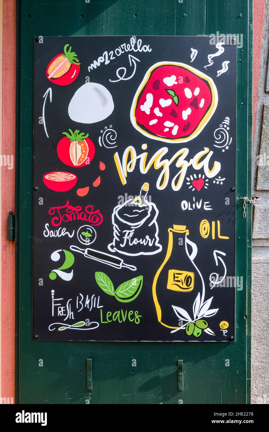 Handbemalte Werbetafel für Pizza neben einer Restauranttür. Stockfoto