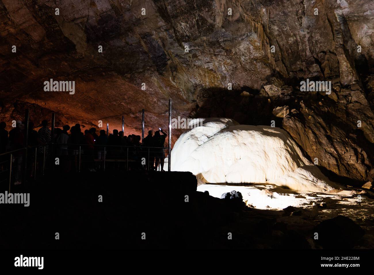 Silhouetten von Touristen in der Höhle des Neuen Athos in Abchasien. Touristenort. Stoloktites und Stologmiten im Untergrund. Stockfoto