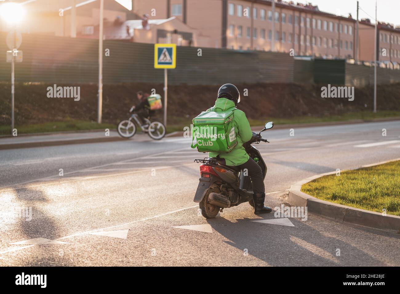 Krasnodar, Russland - Januar 06 2022: Food Delivery Boy auf Roller mit isothermen Lebensmittel-Fall Stockfoto