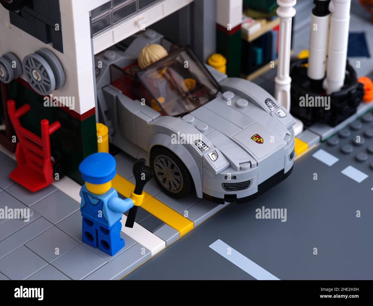 Tambow, Russische Föderation - 03. Januar 2022 Ein Lego Porsche 911 verlässt eine Fahrzeugwerkstatt mit einer Mechaniker-Minifigur in der Nähe Stockfoto