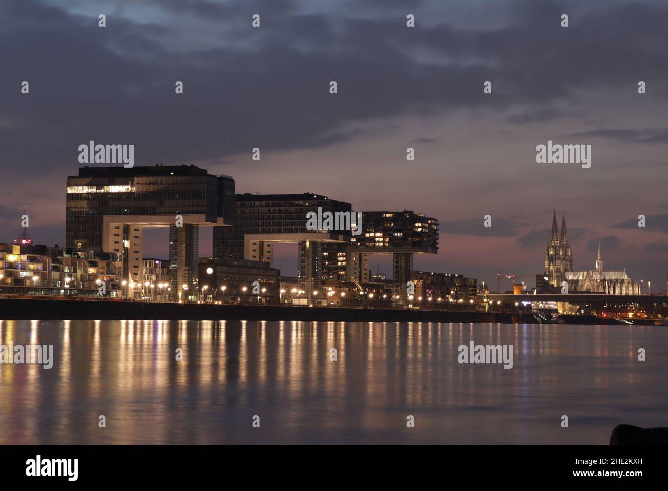Kölner Skyline mit Kranhäusern, Kuppel und Rhein in der Nacht Stockfoto