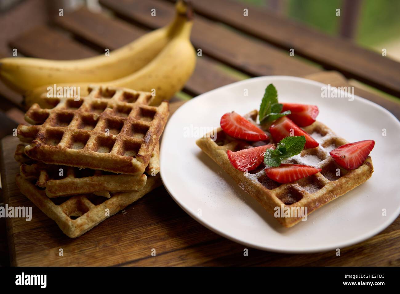 Waffeln mit Erdbeeren, Bananen und Honig. Stockfoto