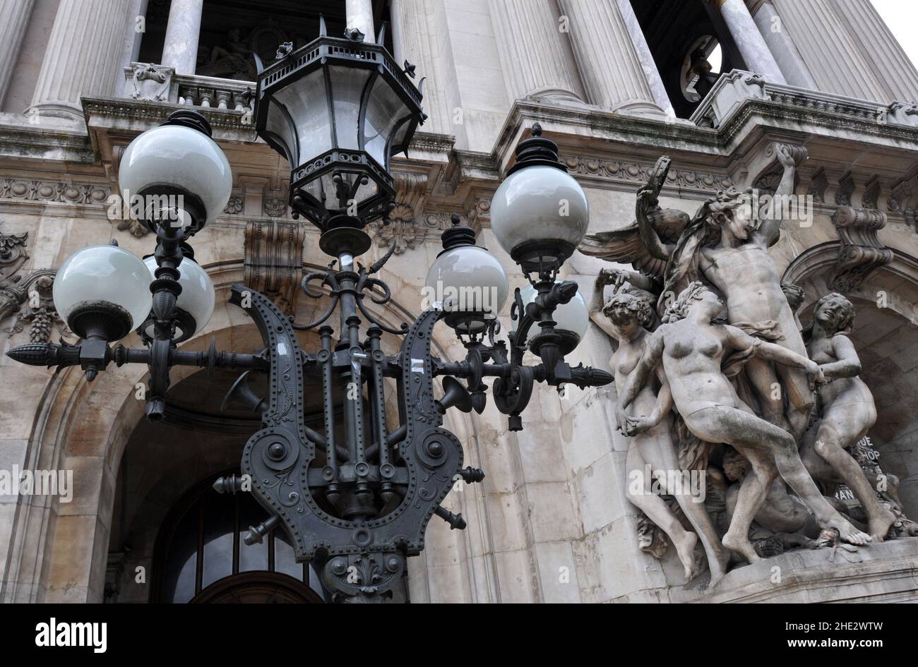 Vor dem Pariser Opernhaus Palais Garnier steht neben der Kopie der Skulptur La Danse von Jean-Baptiste Carpeaux ein reich verzierter Lampenpfosten. Stockfoto