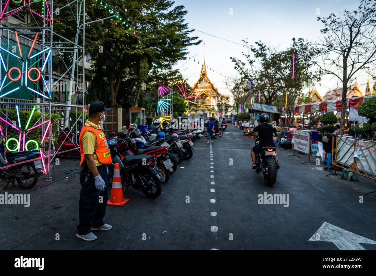 Bangkok, Thailand. 08th Januar 2022. Sicherheitsbeamter leitet den Verkehr an einem Tempelkarneval ab.Familien besuchen am 8. Januar 2021, dem thailändischen Kindertag, einen Tempelkarneval im Wat That Thong. Aufgrund der weltweiten Verbreitung der Omicron-Variante wurden die offiziellen Feierlichkeiten des Jahresurlaubs in Thailand aufgrund einer Zunahme der COVID-19-Fälle abgesagt; private Veranstaltungen dürfen derzeit mit erhöhten Vorsichtsmaßnahmen fortgesetzt werden. Kredit: SOPA Images Limited/Alamy Live Nachrichten Stockfoto