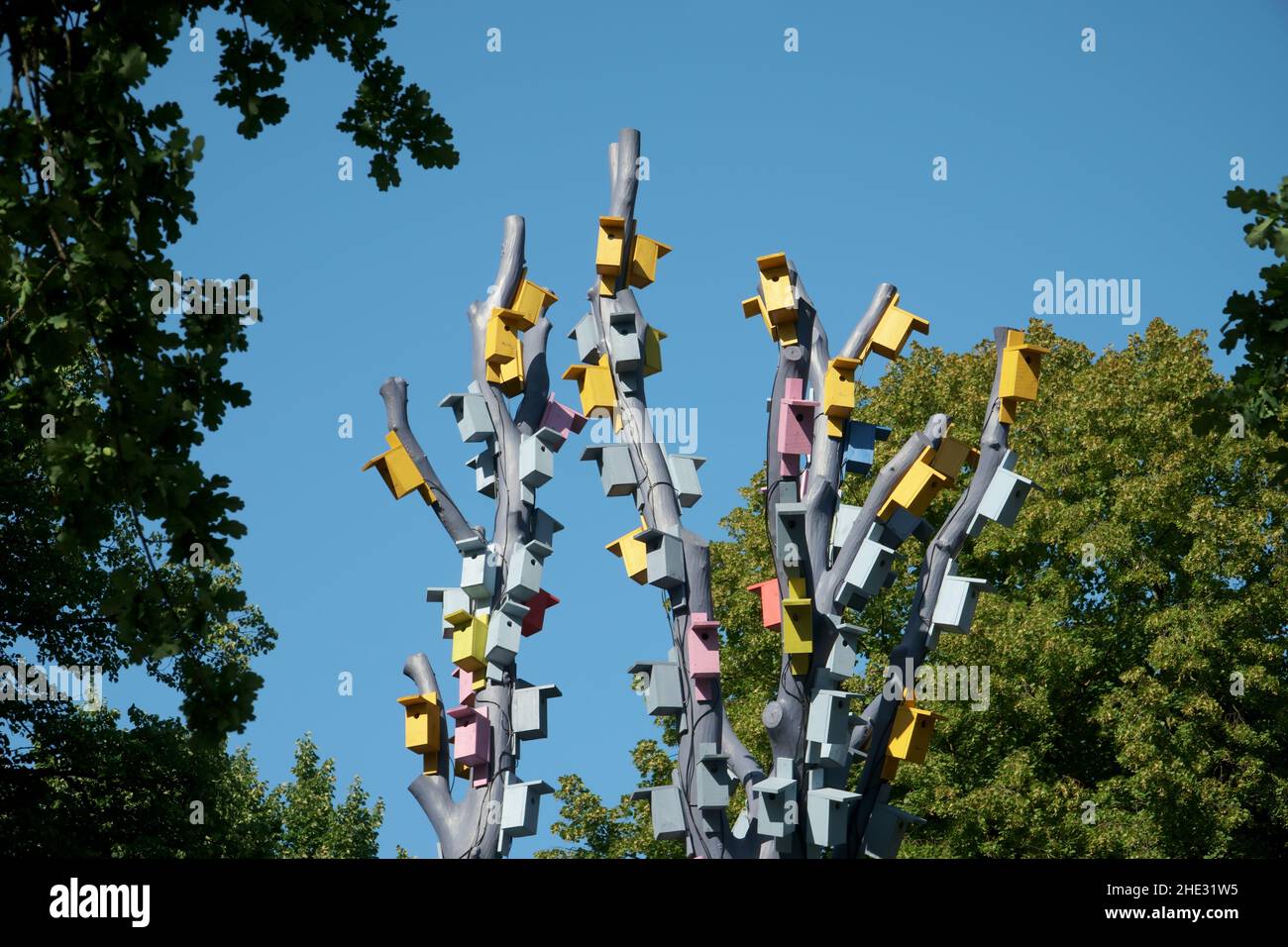 Vogelkäfige in Holzästen. Künstlerische Installation in der Landschaftsgestaltung eines Stadtparks. Kunsthandwerk im urbanen Umfeld. Stockfoto