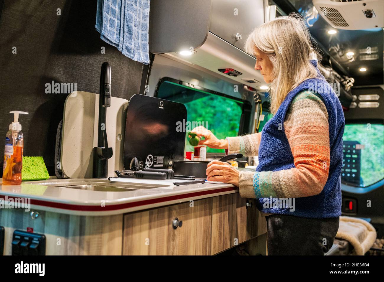 Frau kocht im Wohnmobil Airstream Interstate 24X 4WD; Ainsworth State Park; Columbia River Gorge; Oregon; USA Stockfoto