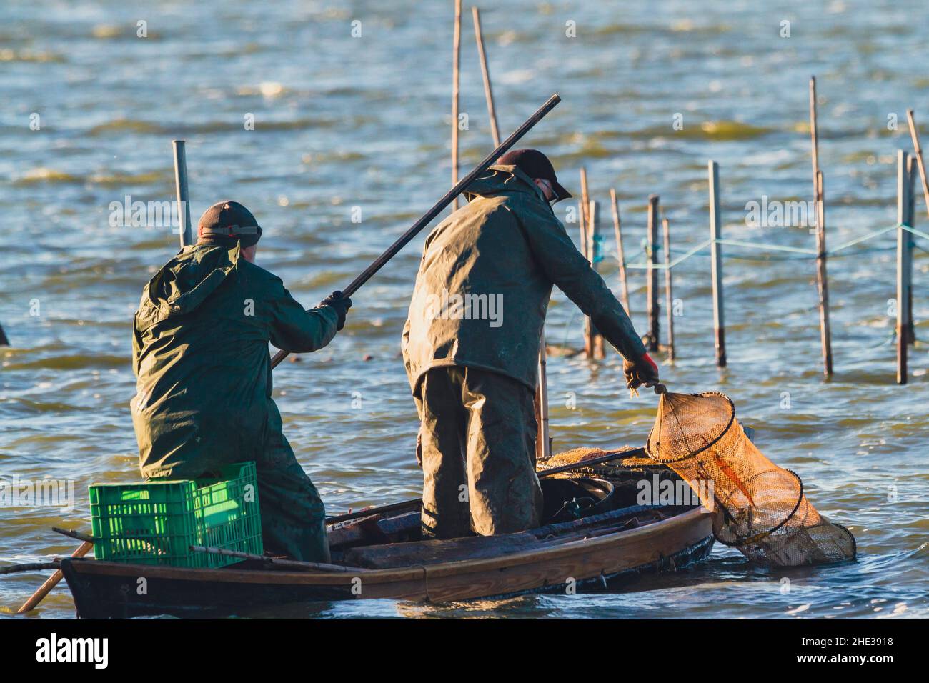 Zwei Fischer fischen im Albufera-See von Valencia in Spanien auf einem traditionellen Boot. Stockfoto