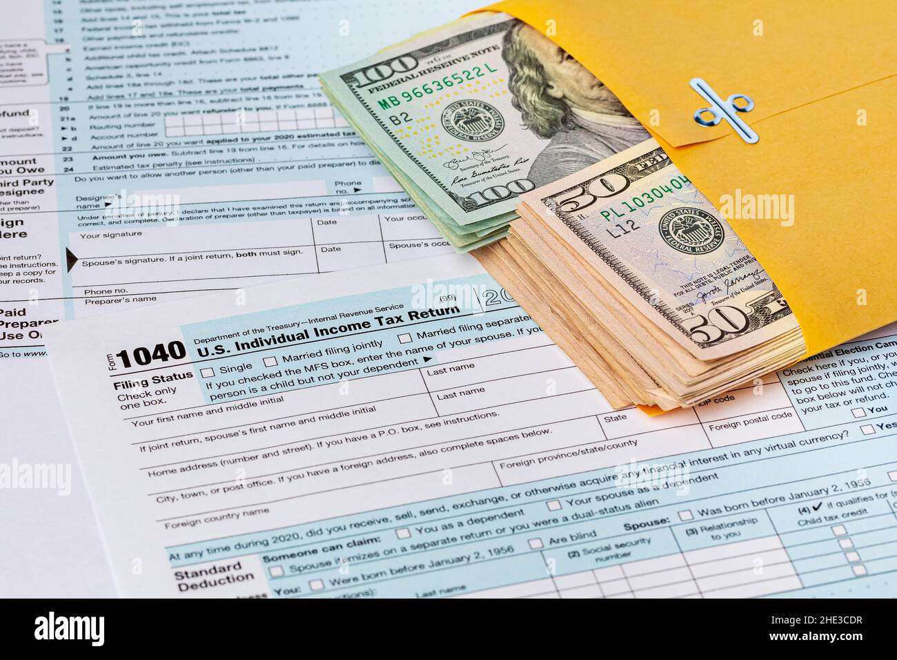 Steuererklärung und Bargeld im Umschlag. Geldwäsche, Steuerhinterziehung und Kriminalitätskonzept. Stockfoto