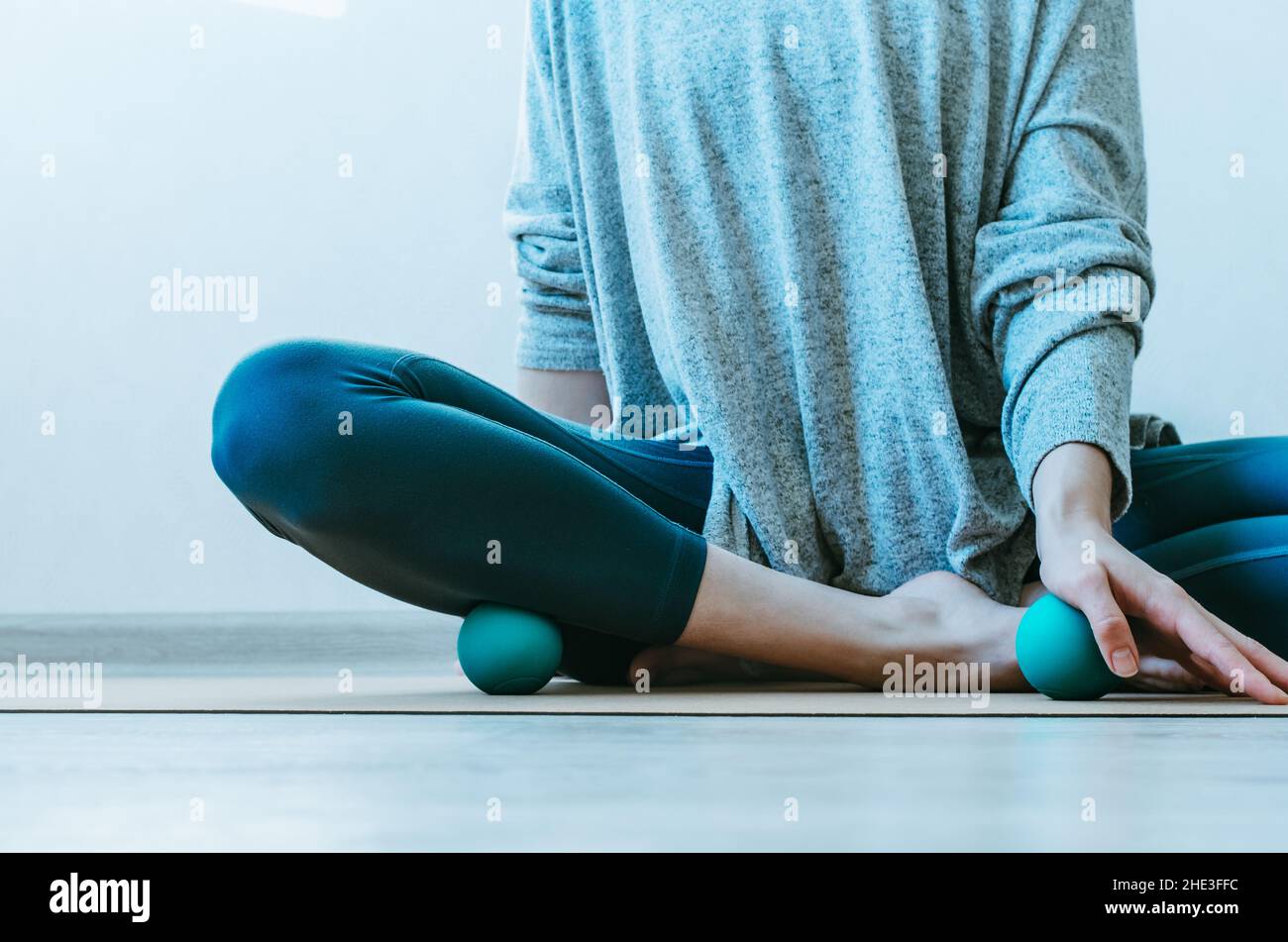 Person, die Yin-Yoga und myofasziale Freisetzung auf Basis von Handflächen- und Schienmuskeln macht. Konzept: Selbstversorgungspraktiken zu Hause, SMFR, Myoyin Stockfoto