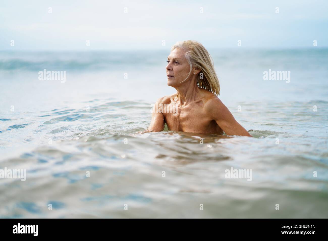 Elderige Frau in gutem Zustand, die im Meer baden. Stockfoto