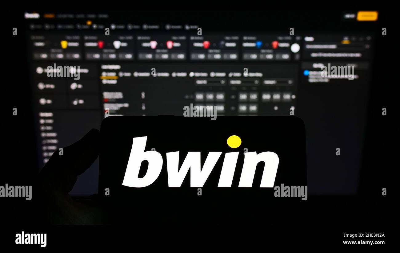 Person, die Smartphone mit Logo der österreichischen bwin Interactive Entertainment AG auf dem Bildschirm vor der Website hält. Konzentrieren Sie sich auf die Telefonanzeige. Stockfoto