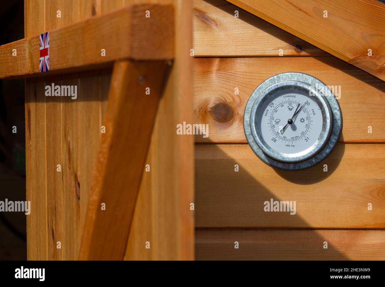 Gartenbarometer an der Seite eines Schuppens zeigt hohen Druck an einem heißen Sommertag im Juni. Stockfoto