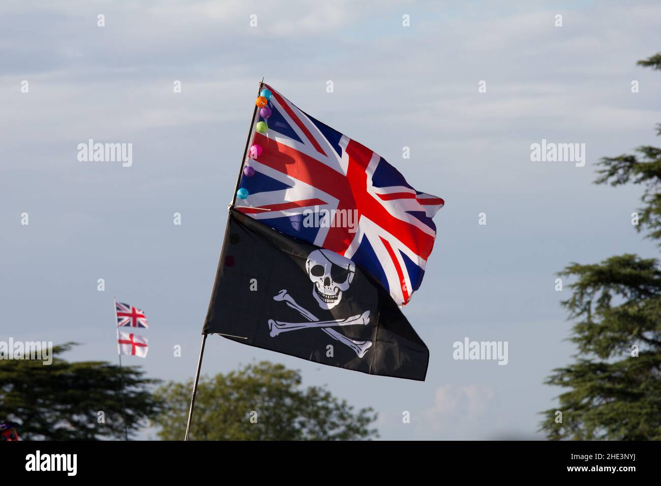 Unionsflagge über einer Piratenflagge von Jolly Roger mit der Flagge von St. George im Hintergrund Stockfoto